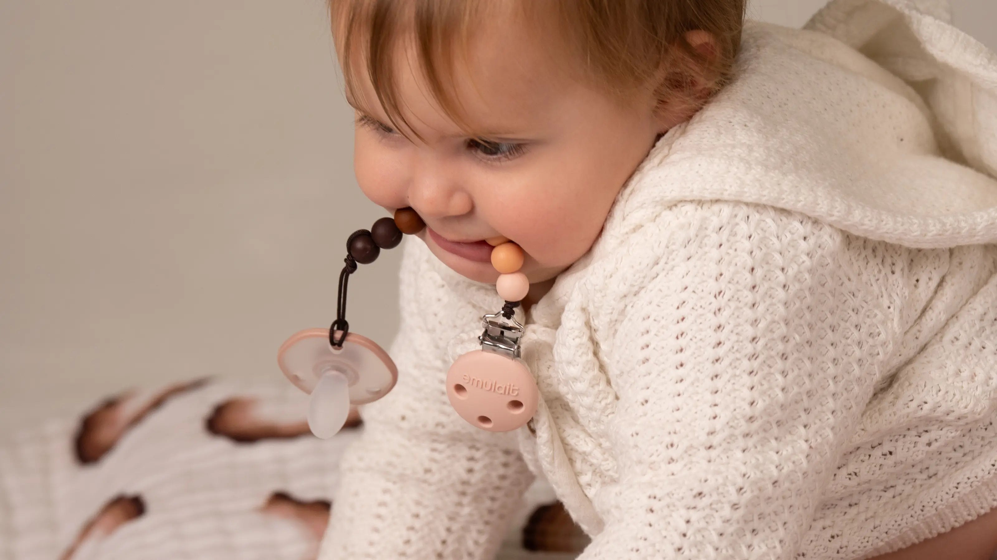 Baby playing with pacifier and pacifier clip