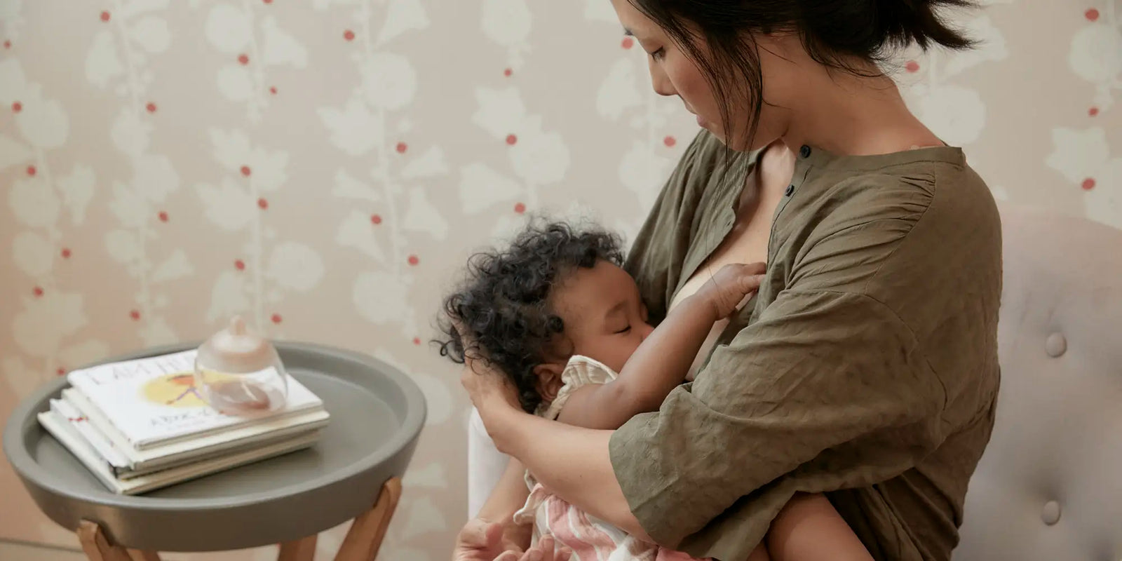 Mother nursing baby using Emulait Anatomy Bottle